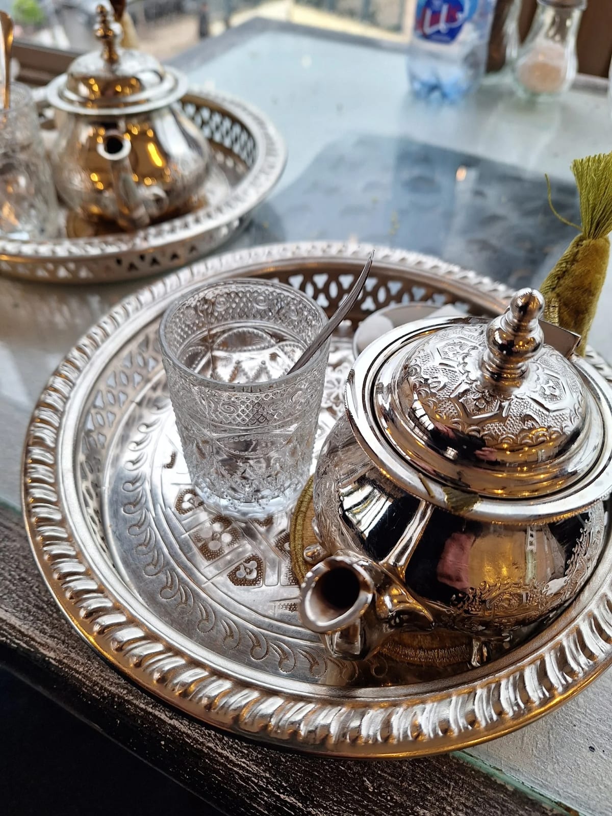 Théière marocaine ciselée et verre à thé sur plateau en argent